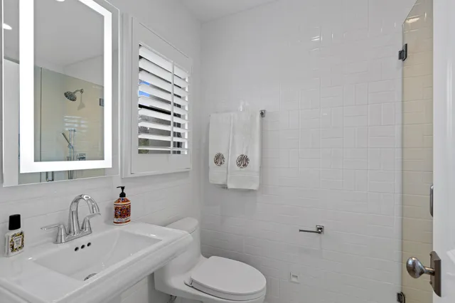 a bathroom with a sink toilet and mirror