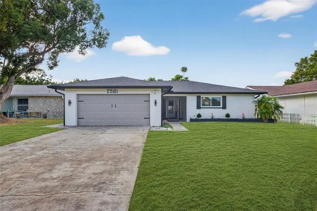 a front view of a house with a garden and yard