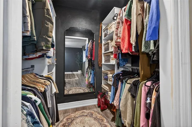 a view of walk in closet with clothes and shoes