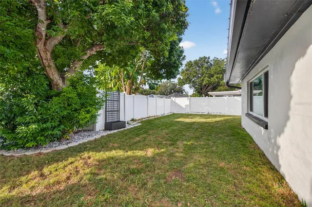 a view of small yard with large trees