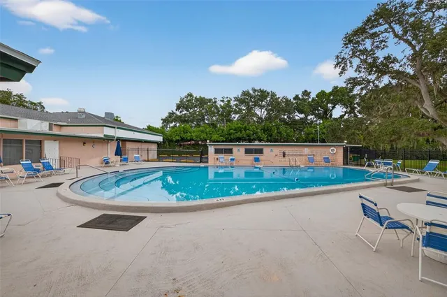 a view of a house with pool and chairs