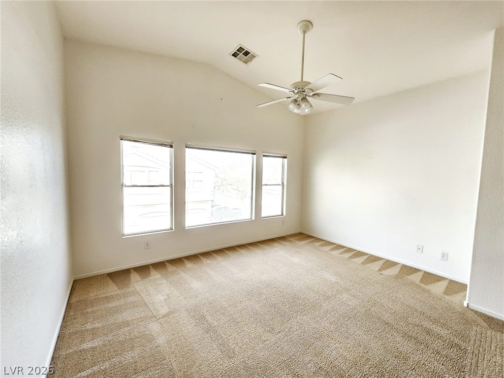 1663 Lefty Garcia Way Henderson, NV 89002 - Photo 24 of 31 A well-lit bedroom with soaring vaulted ceilings and ample natural light through multiple windows.
