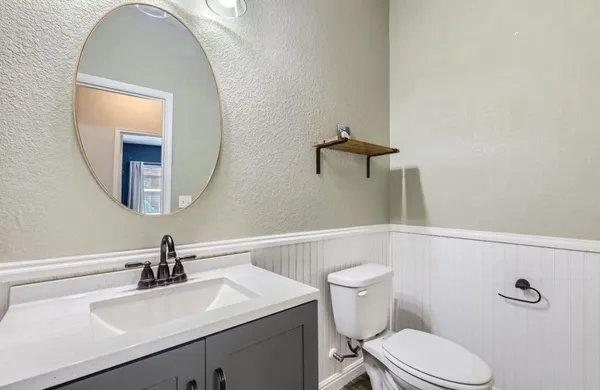 a bathroom with a toilet a sink and mirror