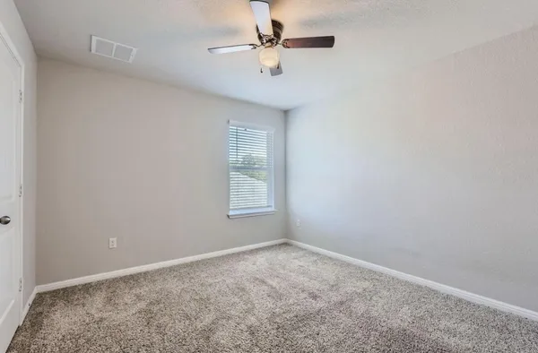 an empty room with a window and a fan