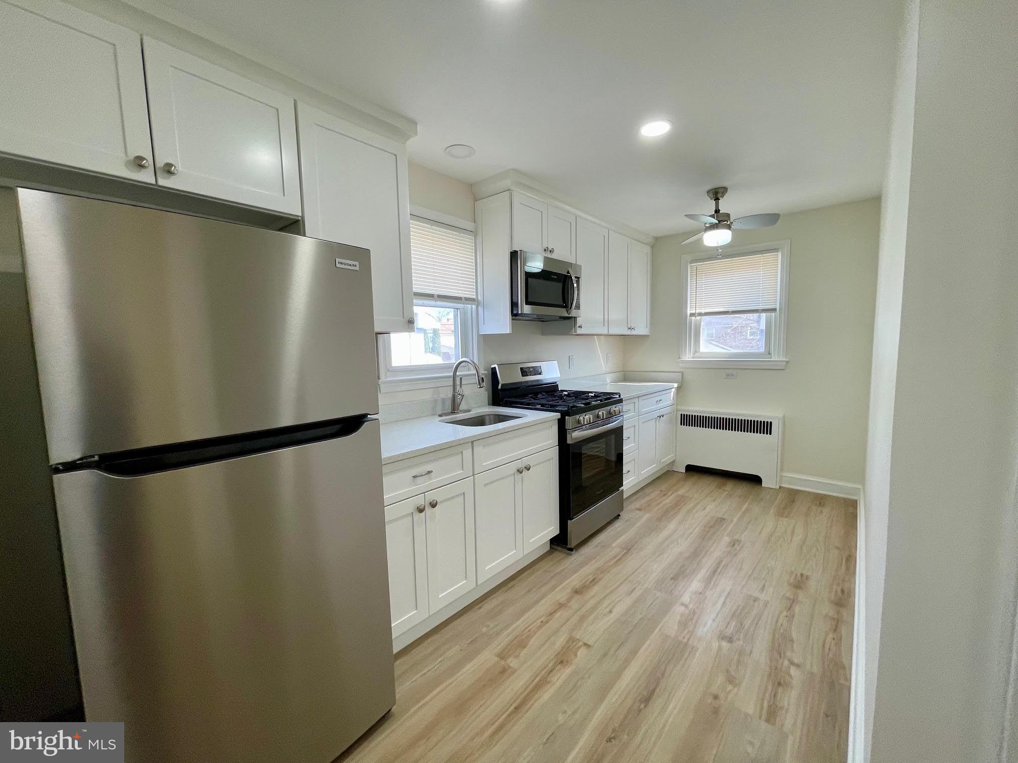 416 East Providence Road Aldan, PA 19018 - Photo 3 of 12 a kitchen with a refrigerator a sink and cabinets