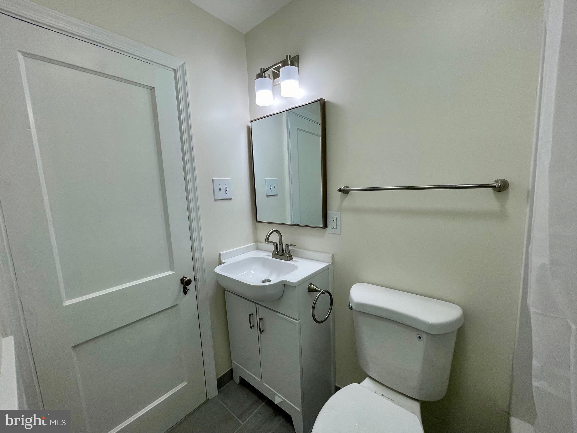 416 East Providence Road Aldan, PA 19018 - Photo 8 of 12 a bathroom with a toilet sink and mirror