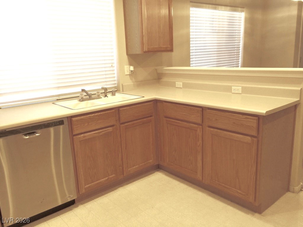 2115 Hidden Ranch Terrace Henderson, NV 89052 - Photo 19 of 30 Kitchen with light countertops, dishwasher, light floors, a peninsula, and wood finish cabinets