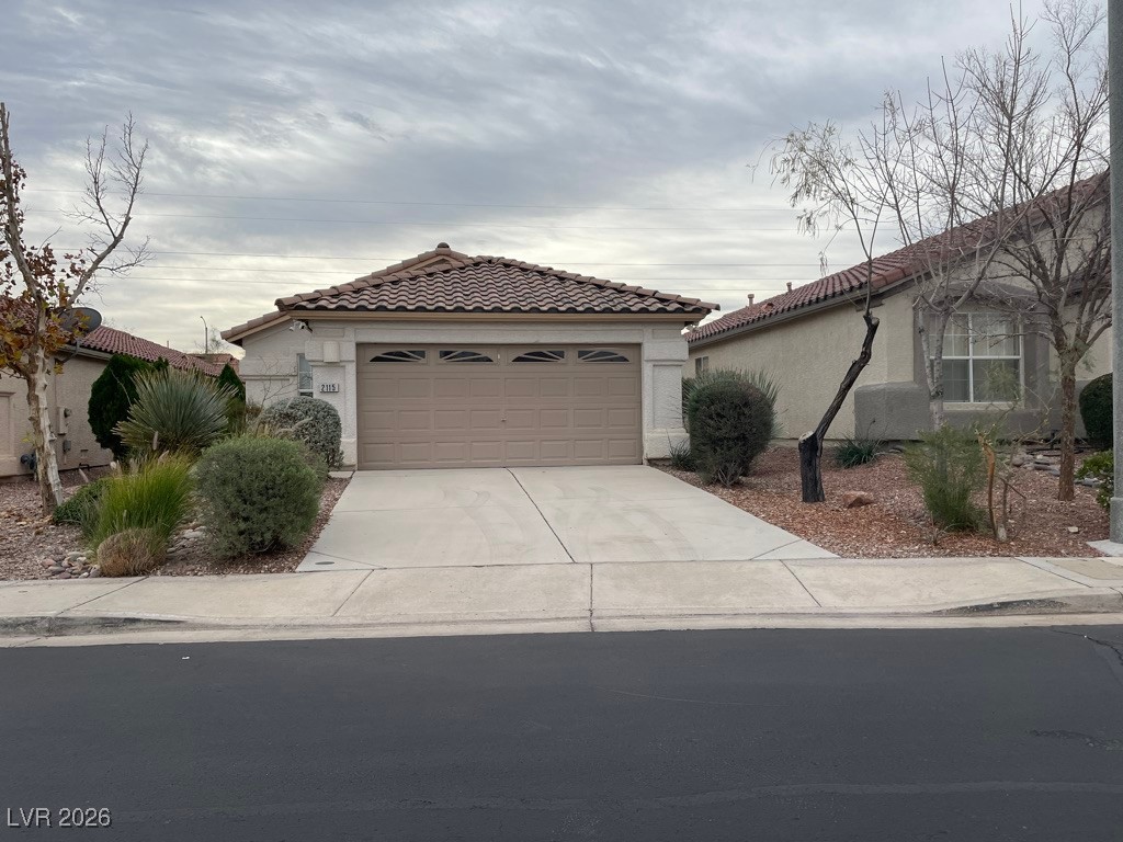 2115 Hidden Ranch Terrace Henderson, NV 89052 - Photo 30 of 30 Mediterranean / spanish-style house featuring a tiled roof, stucco siding, concrete driveway, and a garage