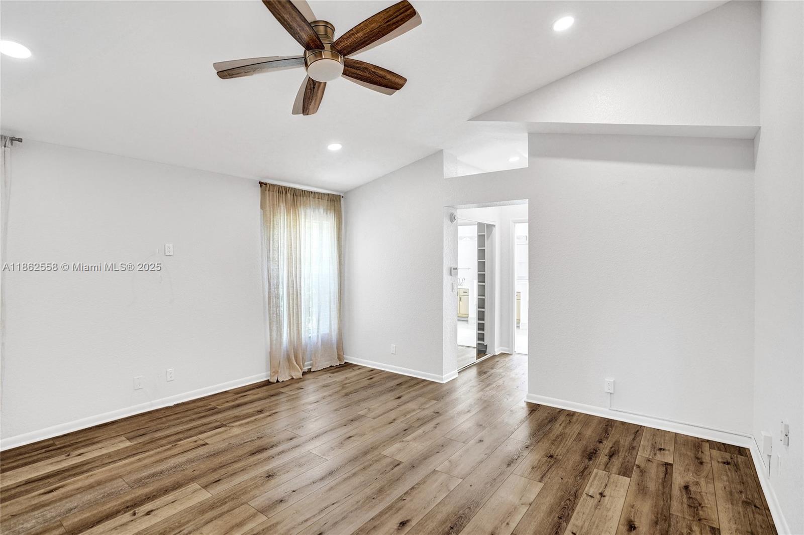 6450 Brava Way Boca Raton, FL 33433 - Photo 27 of 80 an empty room with wooden floor ceiling fan and windows
