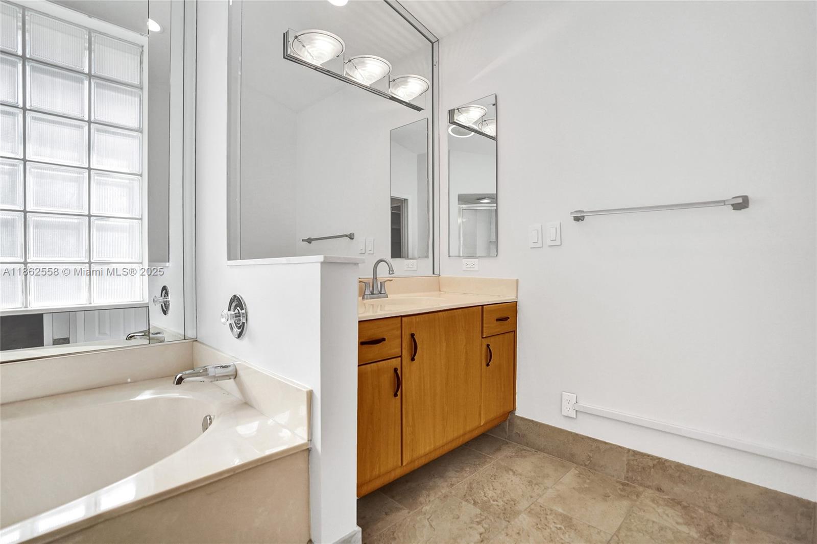 6450 Brava Way Boca Raton, FL 33433 - Photo 32 of 80 a bathroom with a tub sink and mirror