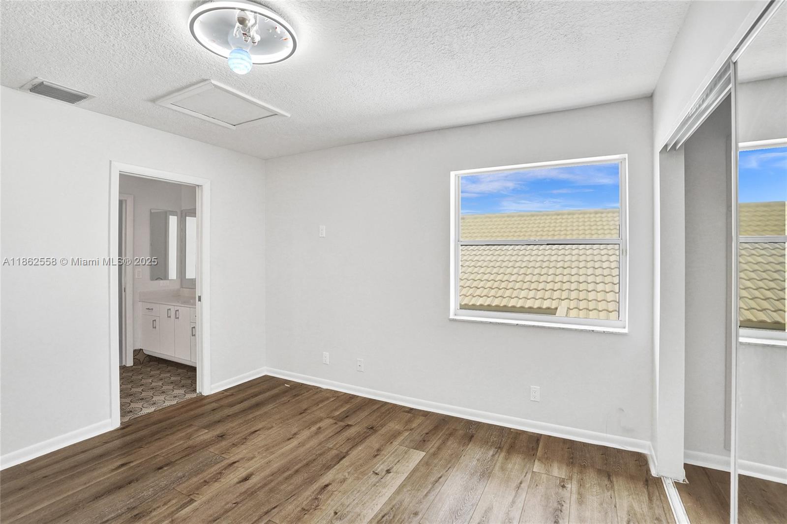6450 Brava Way Boca Raton, FL 33433 - Photo 46 of 80 a view of an empty room with wooden floor and a window