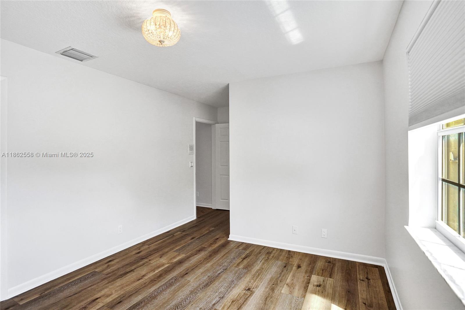 6450 Brava Way Boca Raton, FL 33433 - Photo 52 of 80 an empty room with wooden floor and windows