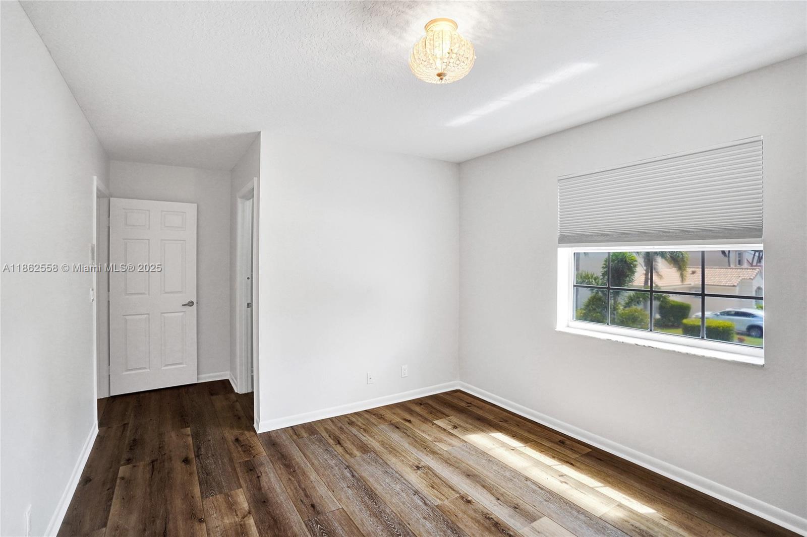 6450 Brava Way Boca Raton, FL 33433 - Photo 53 of 80 a view of an empty room with wooden floor and a window