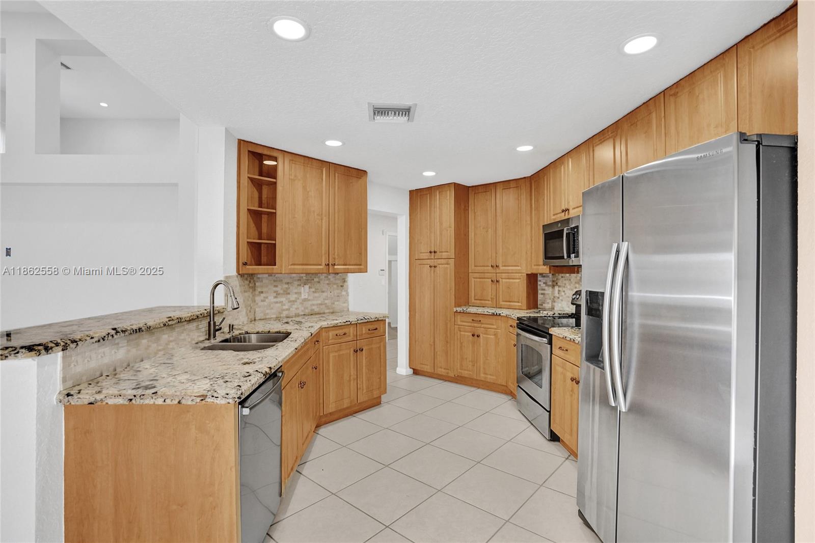 6450 Brava Way Boca Raton, FL 33433 - Photo 7 of 80 a kitchen with stainless steel appliances granite countertop a sink stove and refrigerator