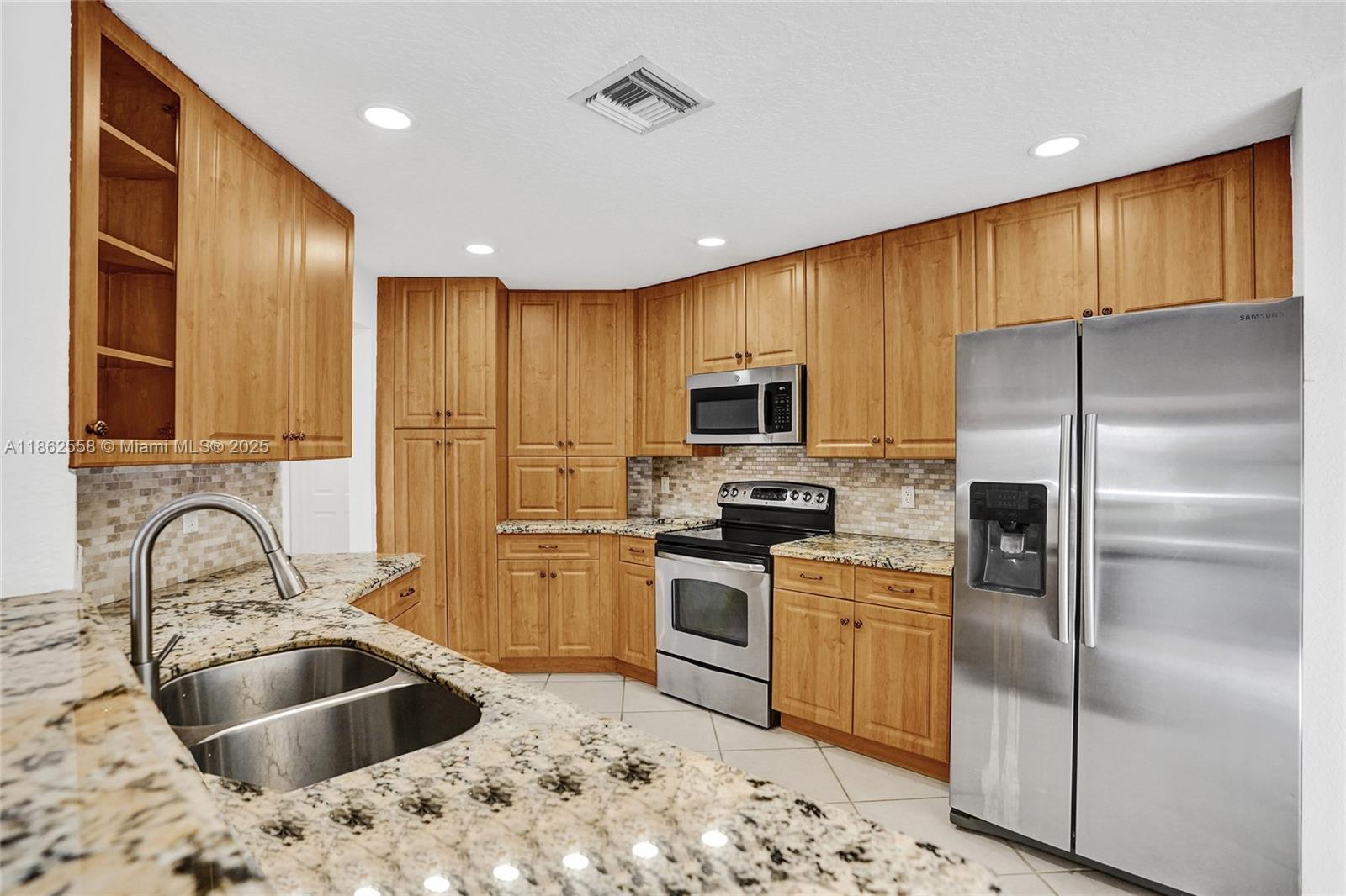 6450 Brava Way Boca Raton, FL 33433 - Photo 9 of 80 a kitchen with stainless steel appliances a refrigerator sink and microwave