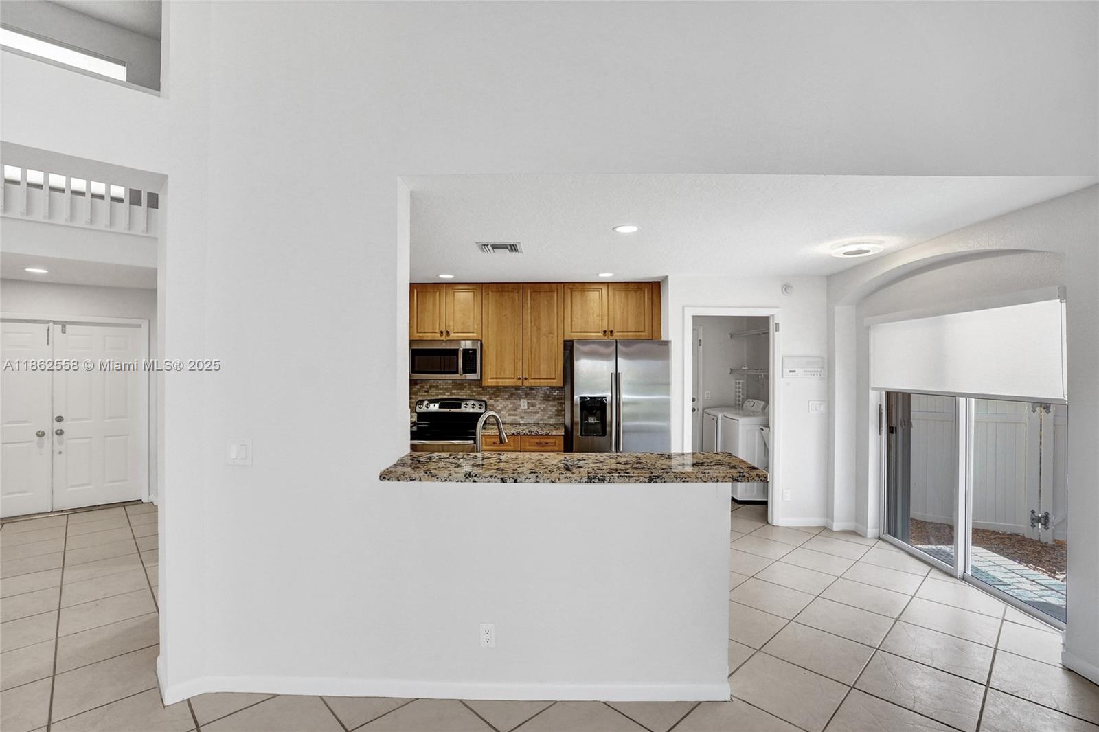 6450 Brava Way Boca Raton, FL 33433 - Photo 10 of 80 a large kitchen with stainless steel appliances a refrigerator and a stove top oven
