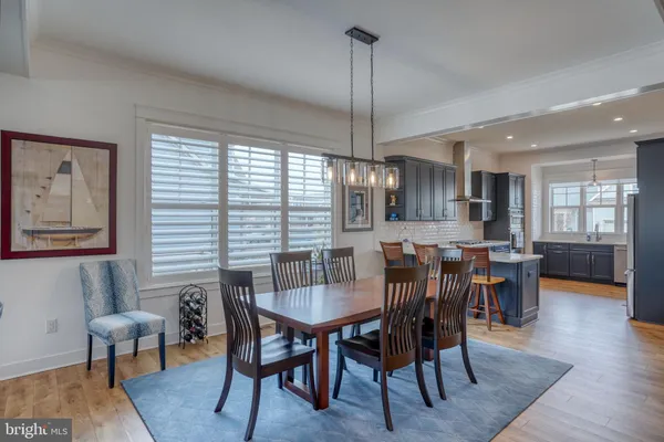 a view of a dining room and livingroom with lots of furniture wooden floor a chandelier