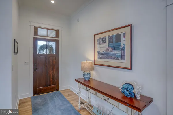 a view of a dining room and livingroom with furniture wooden floor a rug a chandelier