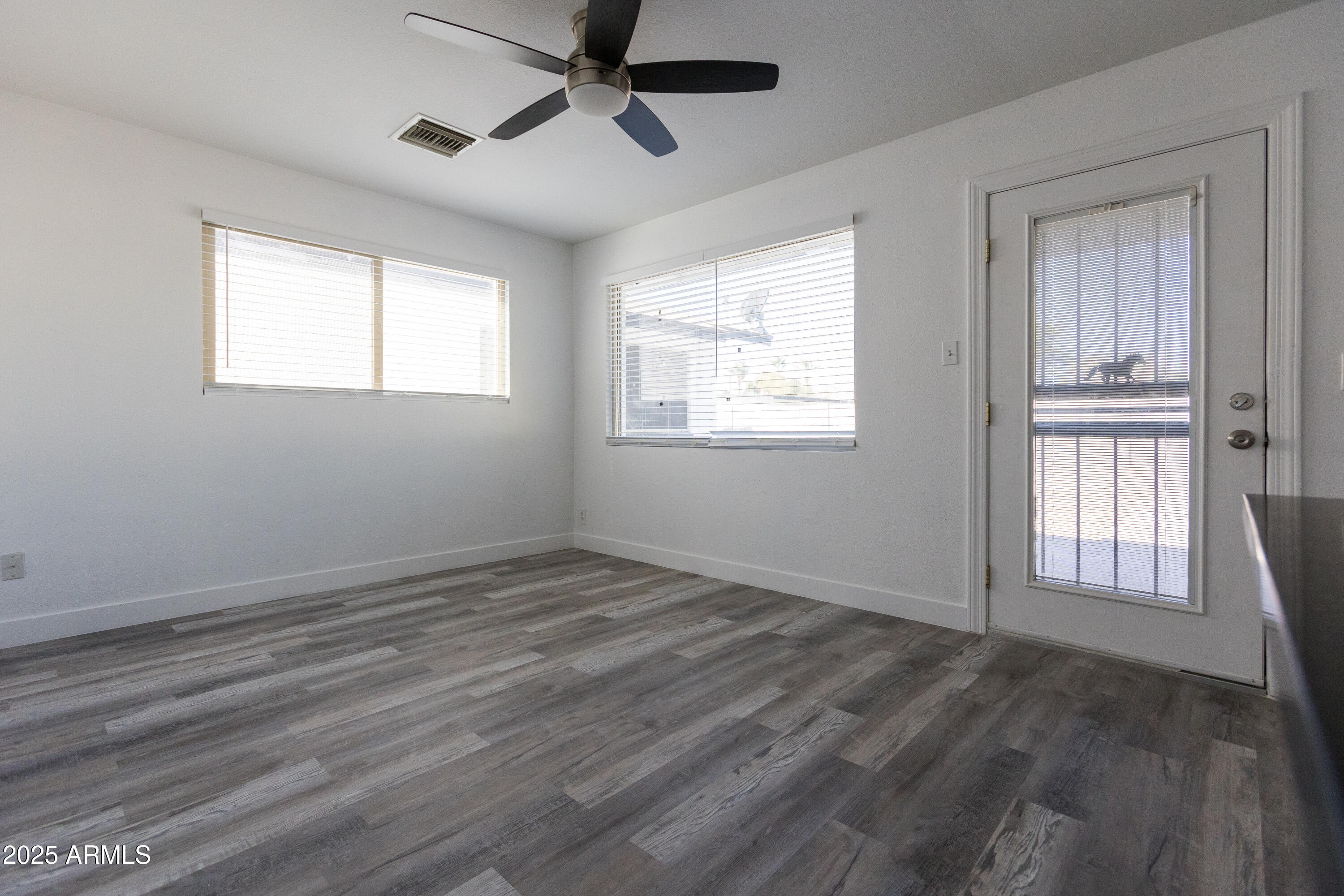 3417 East Windsor Avenue, Unit 2 Phoenix, AZ 85008 - Photo 2 of 12 a view of empty room with wooden floor and fan