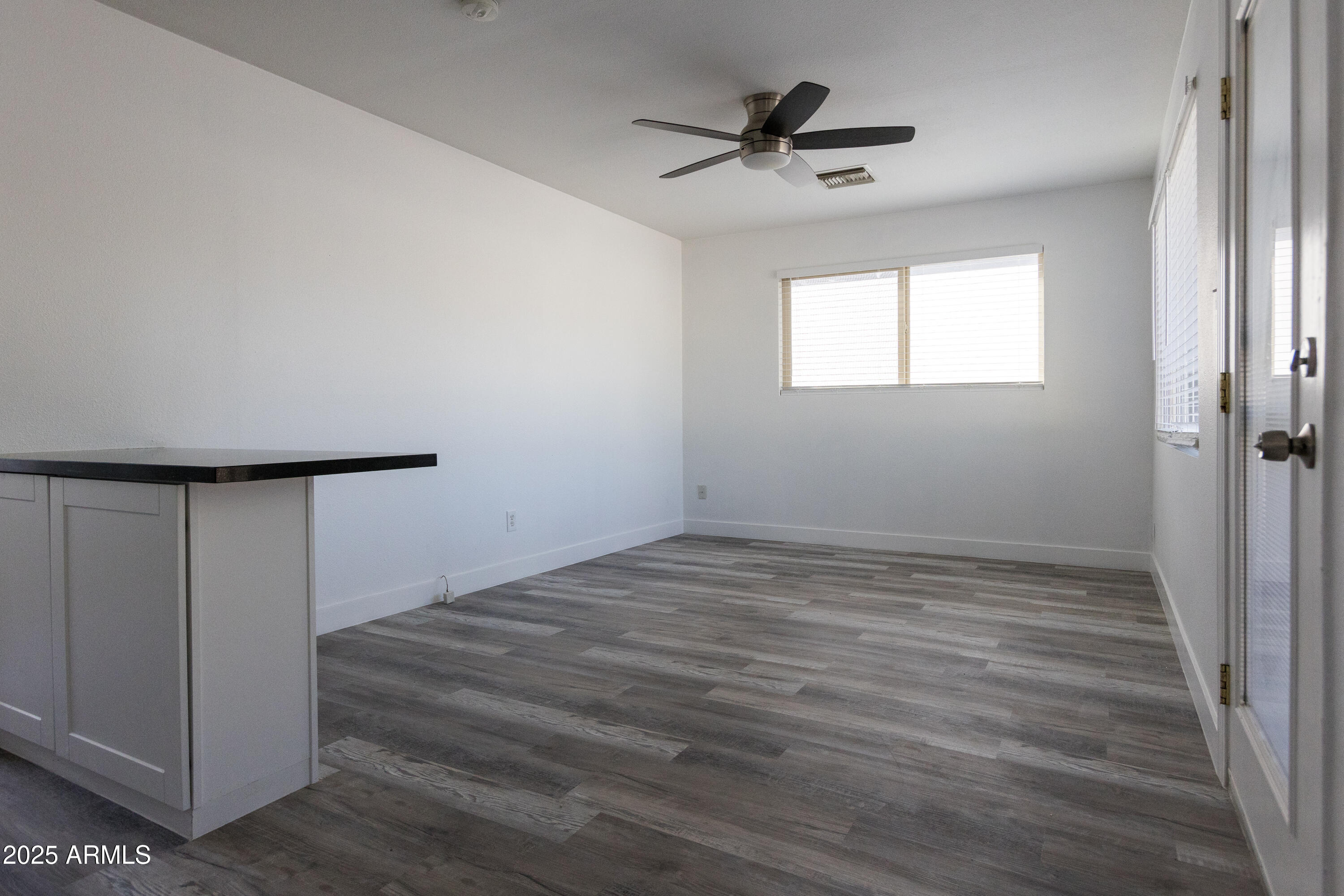 3417 East Windsor Avenue, Unit 2 Phoenix, AZ 85008 - Photo 4 of 12 a view of a livingroom with wooden floor and a ceiling fan