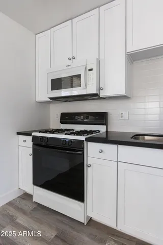 a kitchen with stainless steel appliances granite countertop a stove a microwave and cabinets