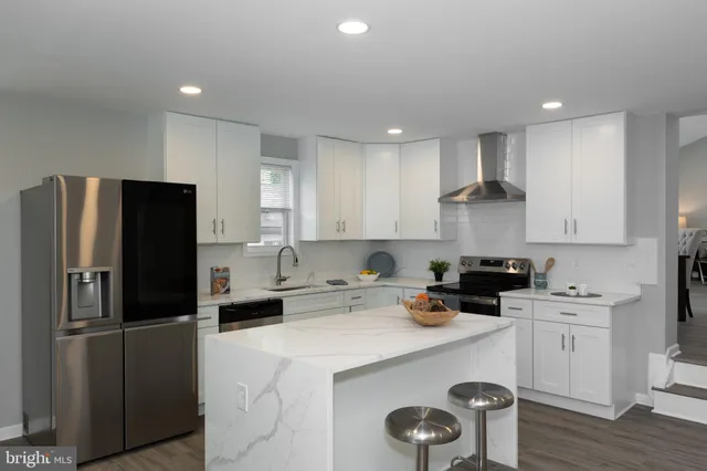 a kitchen with a refrigerator a stove a sink and cabinets