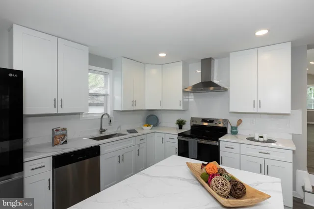 a kitchen with granite countertop a sink a stove and cabinets