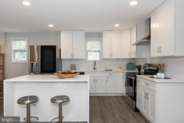 a kitchen with a sink a stove a refrigerator and white cabinets