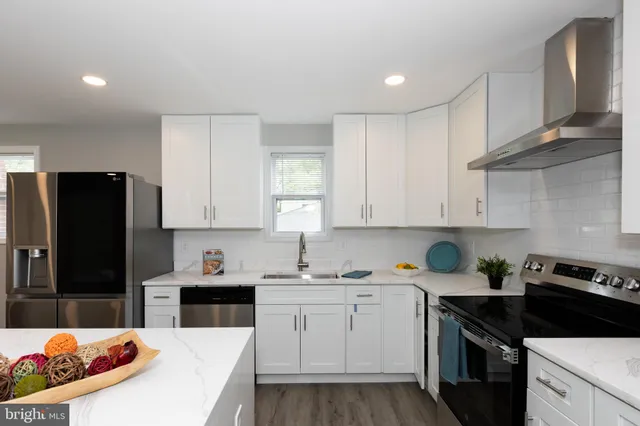 a kitchen with a sink a refrigerator and cabinets