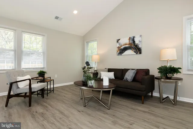 a living room with furniture and a wooden floor