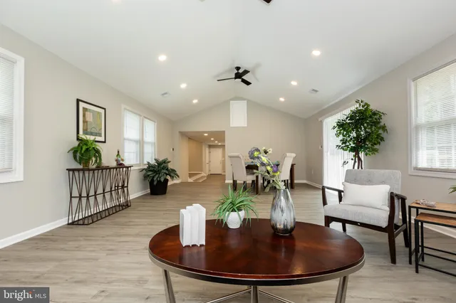 a dining room with furniture a chandelier and wooden floor