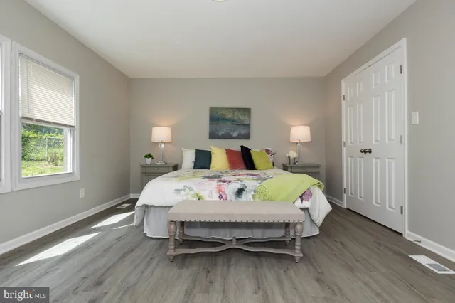 a bedroom with a bed and wooden floor