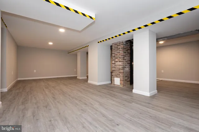 a view of an empty room with wooden floor and stairs