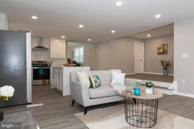 a living room with kitchen island furniture and a dining table with kitchen view