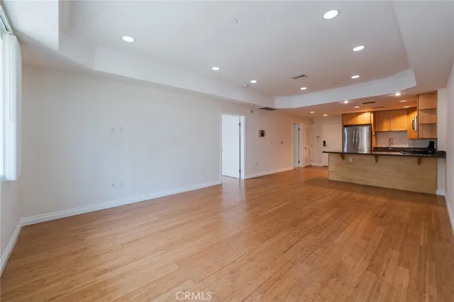 a view of a big room with wooden floor and a window