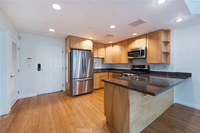 a kitchen with kitchen island granite countertop a sink and refrigerator