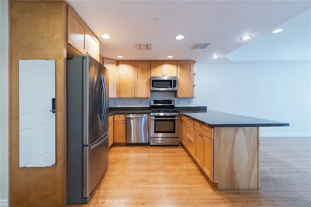 a kitchen with stainless steel appliances granite countertop a refrigerator and a stove