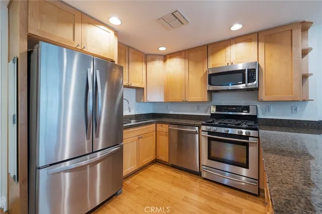 a kitchen with stainless steel appliances granite countertop a refrigerator stove and microwave