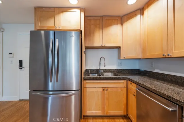 a kitchen with stainless steel appliances granite countertop a refrigerator sink and cabinets