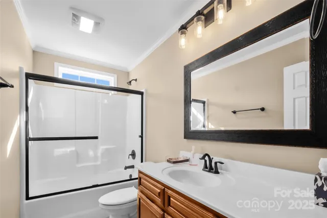 a bathroom with a sink a mirror a toilet and shower