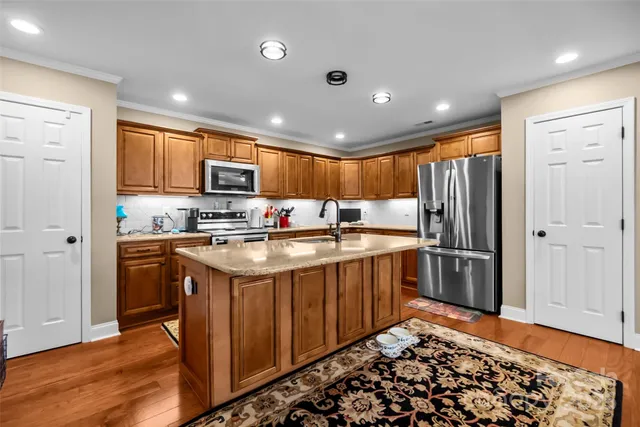 a kitchen with stainless steel appliances granite countertop a refrigerator stove and sink