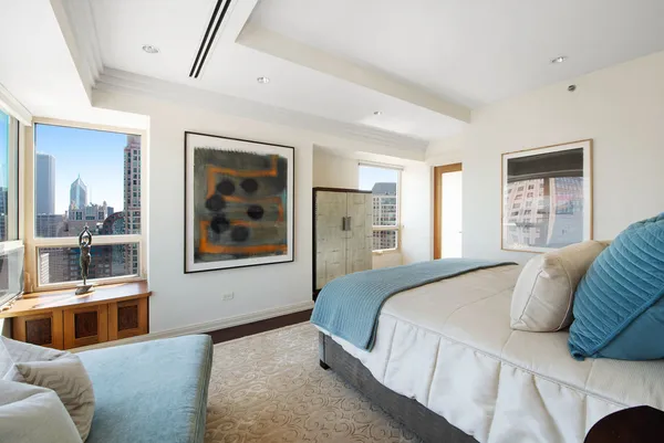 a bedroom with a large bed couch and window