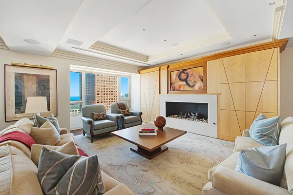 a living room with furniture a fireplace and a large window