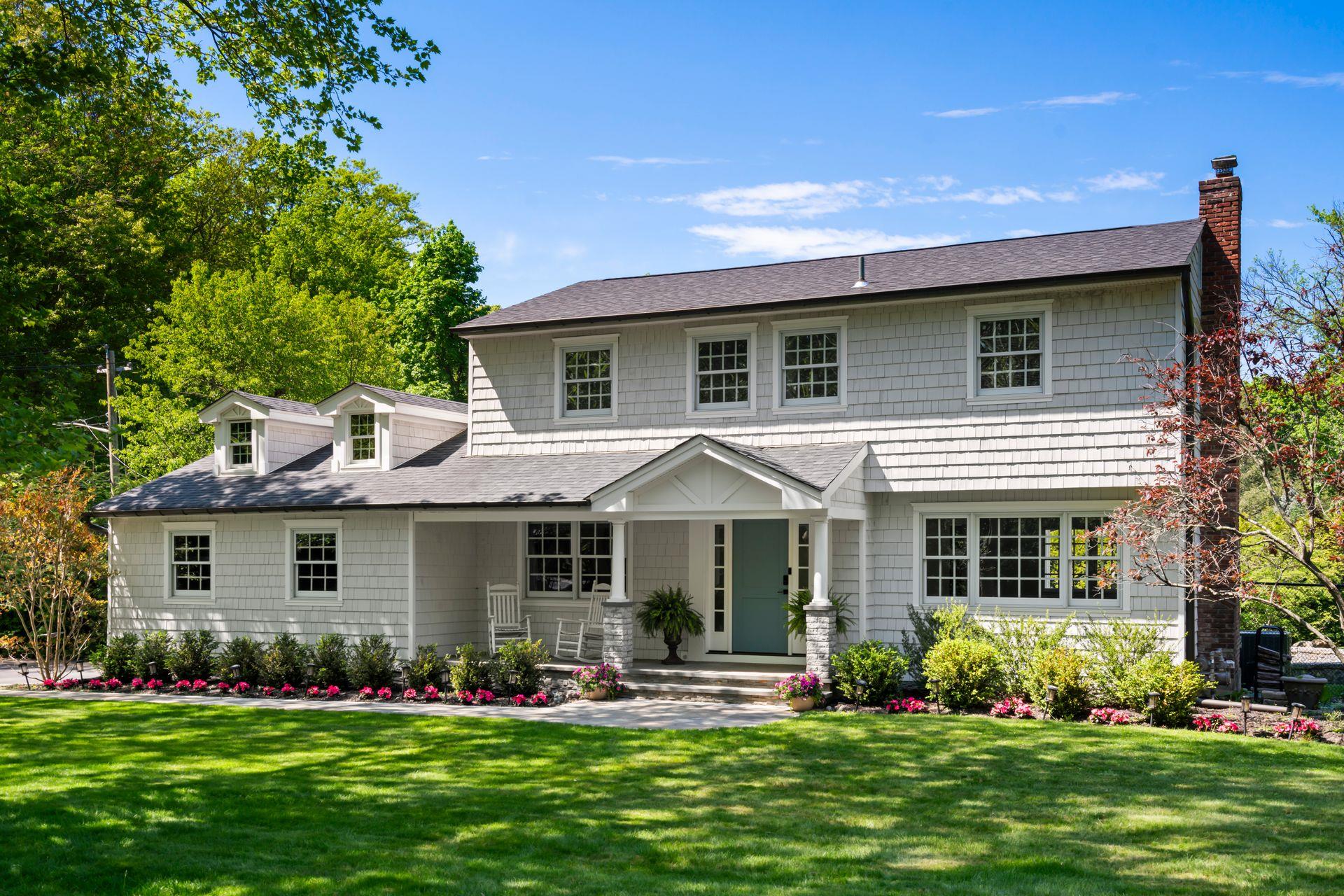 View of front of home featuring, inviting porch, cedar shingles and new architectural roof