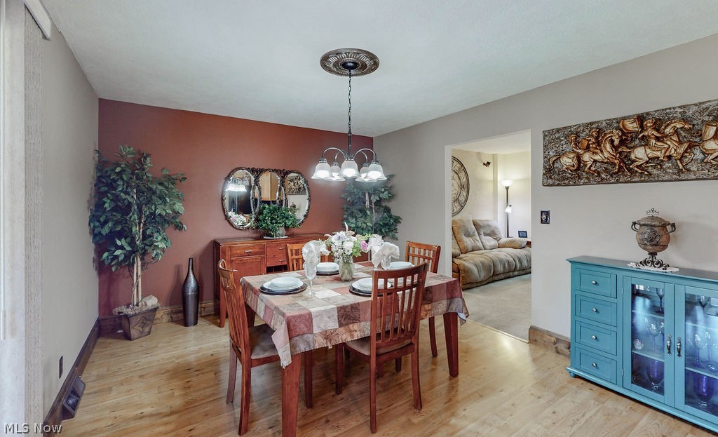 3137 Queen Road Ravenna, OH 44266 - Photo 11 of 33 Dining room featuring light wood-type flooring and a notable chandelier