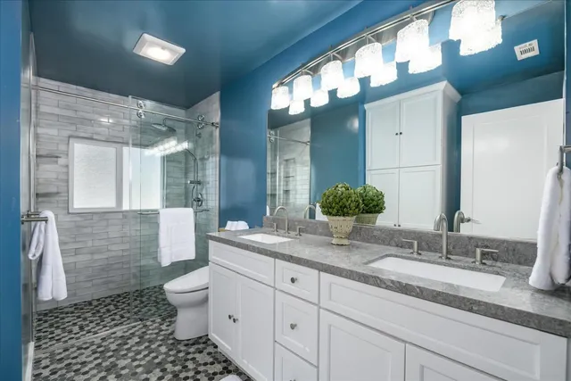 a bathroom with a granite countertop sink mirror vanity and toilet