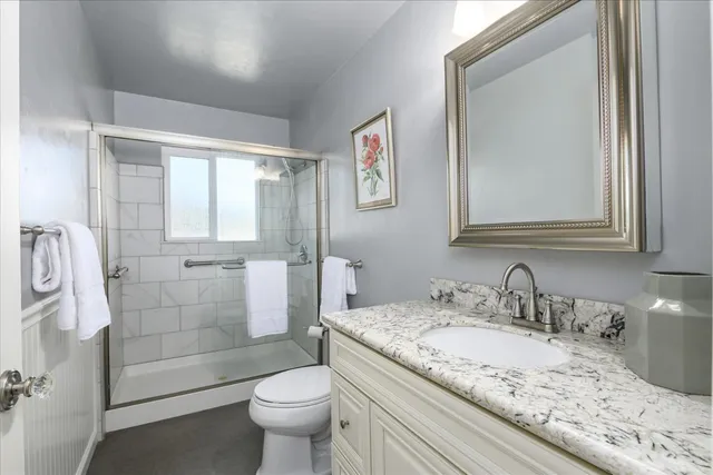 a bathroom with a granite countertop sink toilet and shower