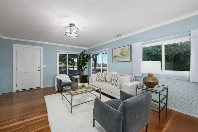 a living room with furniture and wooden floor