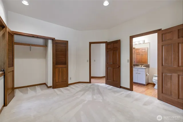 an empty room with closet and a bathroom