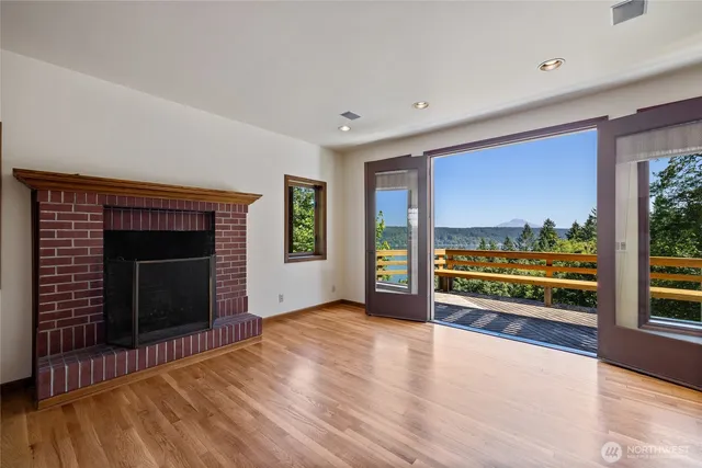 a view of an empty room with a fireplace and a floor to ceiling window